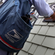 U.S. Postal Service letter carrier Anthony Ow places letters in a mailbox as he walks his delivery route July 30, 2009, in San Francisco. (Justin Sullivan/Getty Images)